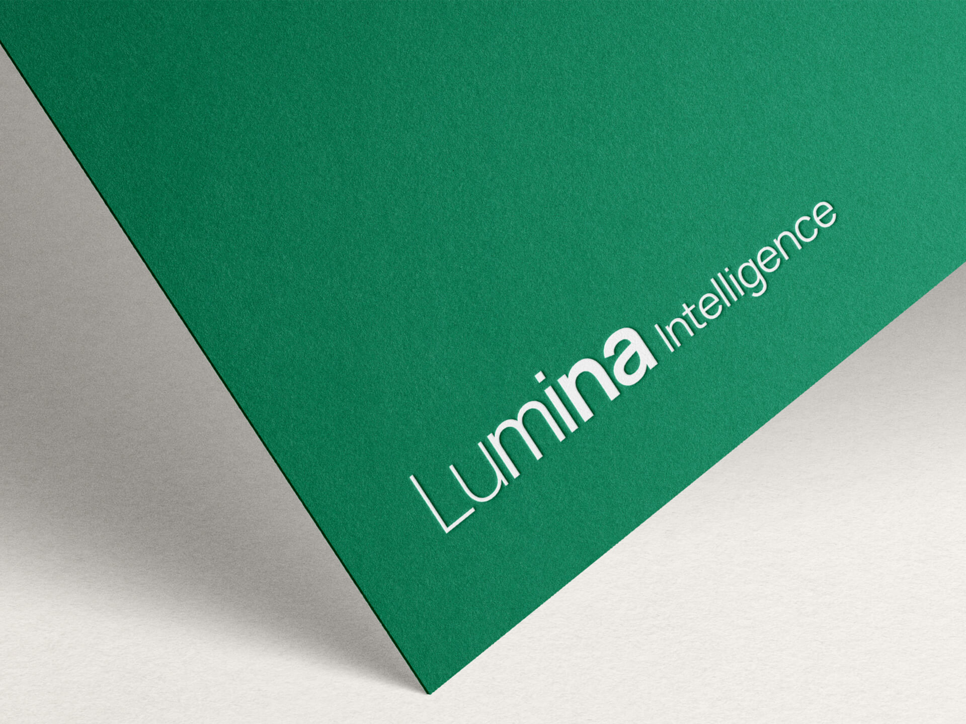 A close up of the Lumina Intelligence logo printed on a piece of green card